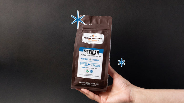 A bag of Sumatra Swiss Water Decaf being held up by a hand.