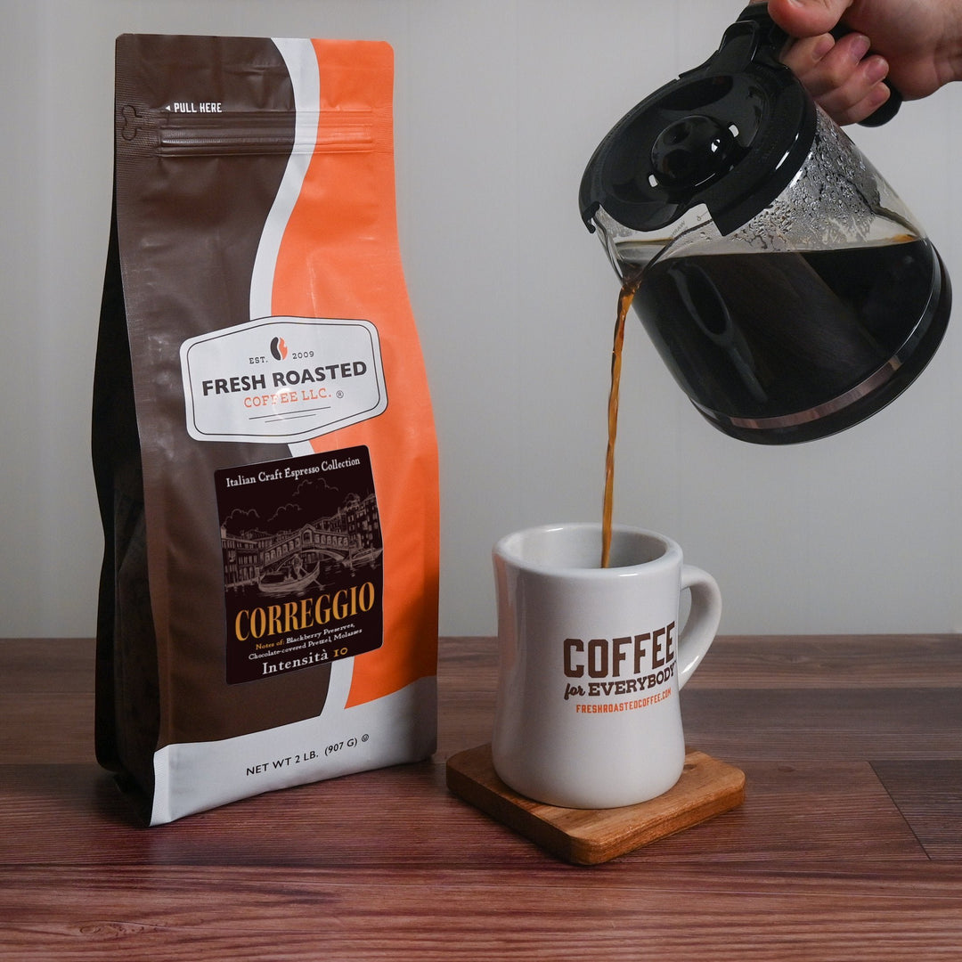 Fresh Roasted Coffee Correggio espresso brewed and poured into a ceramic mug, showcasing its deep, bold Italian roast flavor.